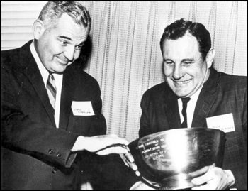 Two football coaches struggle to grasp a trophy: Tallahassee, Florida (1961)