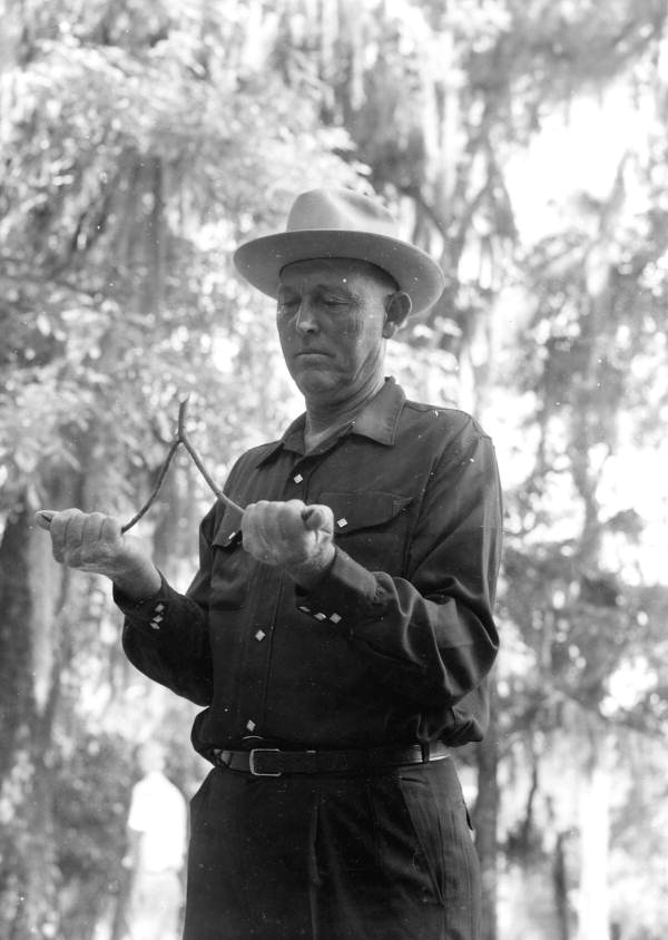 Water witcher Lonnie Morgan of White Springs holding a dowsing rod at the Florida Folk Festival in 1958.