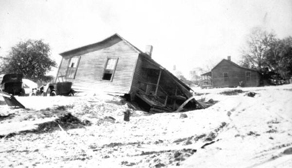 Wreckage of homes and cars after hurricane (photo likely 1928).