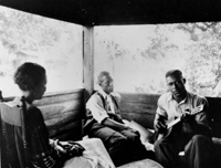 Gabriel Brown playing guitar as Rochelle French and Zora Neale Hurston listen: Eatonville, Florida, 1935