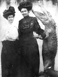 Two women posing with a stuffed alligator (19--)