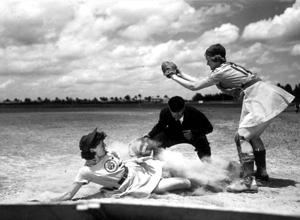 All American Girls Professional Baseball League player Marg Callaghan sliding into home plate as umpire Norris Ward watches: Opa-locka, Florida (1948)