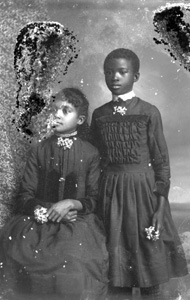 Two girls wearing dark dresses