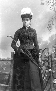 Woman wearing beaded dress, with hat