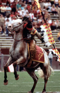 Florida State University's mascot, "Chief Osceola" riding Renegade before a game at Doak Campbell Stadium: Tallahassee, Florida (1970s)