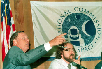 Neil Armstrong and Leonard David gesture during a meeting of the National Commission of Space: Tallahassee, Florida (1985)