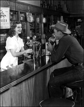 Unidentified cowboy gets a soda from the soda shop: Bonifay, Florida (1949)