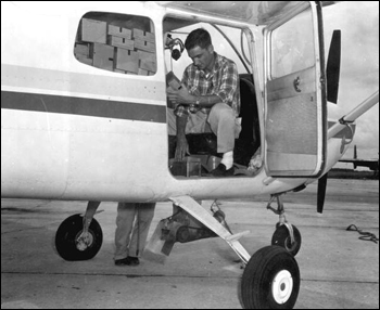 Pilot prepares boxes of sterile screwworm pupae to be dropped on a cattle ranch : Sebring, Florida (1958)