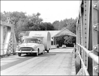 Car and trailer crossing a bridge: Astor, Florida (1957)