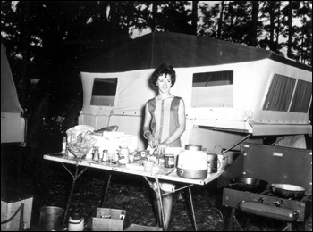 Young woman prepares a meal at a camping convention: Gainesville, Florida (1962)