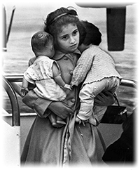 Young Cuban refugee holding her dolls in airport (1961)