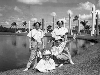 Sales representatives in spacettes costume pose before the rocket entranceway of Tupperware Home Parties Inc., in Orlando, Florida