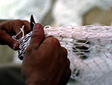 Net maker at work repairing a fishing net: Fernandina Beach, Florida