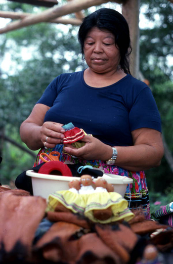 Mary Billie putting skirt on the Seminole doll she is making: Big Cypress Seminole Indian Reservation, Florida 