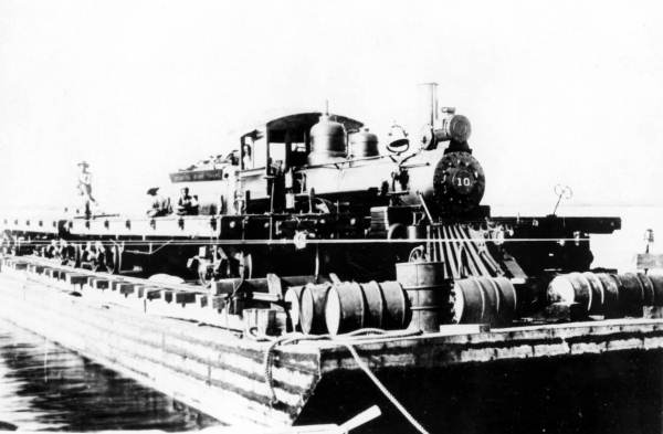 Florida East Coast Railway engine #10 crossing Lake Surprise on a barge. The engine was used by railroad work crews during construction to transport workers, supplies, and building materials (1906).