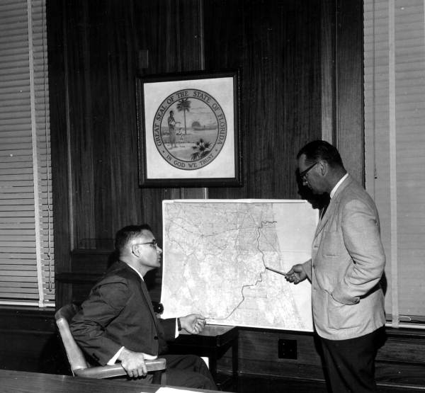 Florida Secretary of State Tom Adams and Board of Conservation Director Randolph Hodges study a map of the proposed Cross Florida Barge Canal (1961).