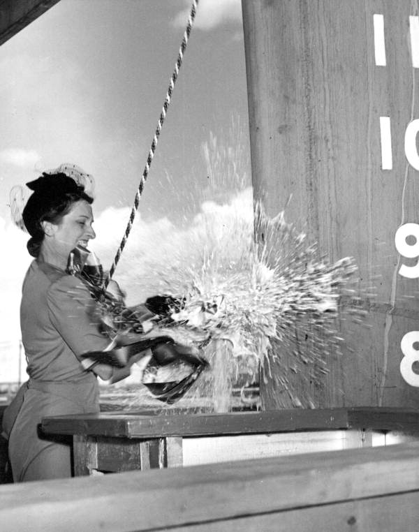 First Lady Mary Groover Holland breaks a bottle of champagne against the hull of the USS Shasta, built by the Tampa Shipbuilding Company (July 9, 1941).