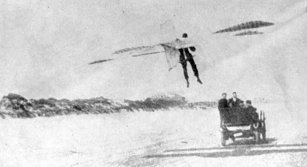 Edwin F. Andrews is towed behind a car on Daytona Beach while wearing his gliding apparatus (1911).