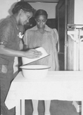 Certified nurse midwife showing helper how to remove cover from the boiled cotton for delivery.