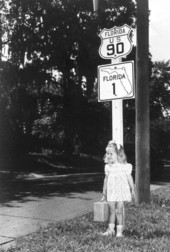 Young Carolyn Rae Sandgren stands next to highway markers for U.S. 90 and Florida Highway 1