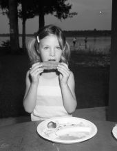 Young girl eating mullet fish at the bayou mullet festival - Niceville, Florida