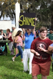 Gun-control activist holding up her sign at the Never Again Rally in Tallahassee.