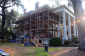 Brick restoration worker walking adjacent to scaffolding during first phase of historic rehabilitation and restoration at the Call-Collins House at The Grove in Tallahassee, Florida.