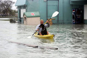 Man kayaking with dog on Flagler Avenue by the Salvation Army store - Key West, Florida.