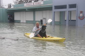 Man kayaking with dog on Flagler Avenue in front of the Salvation Army store - Key West, Florida.