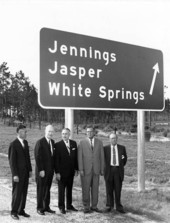 Governor Bryant and other in front of the traffic sign