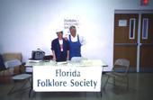 Members of the Florida Folklore Society standing by table at the Zora Neale Hurston Festival of the Arts and Humanities - Eatonville, Florida