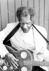 Blind Johnny Brown playing his resonator guitar and singing blues for a field tape.