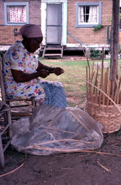 Lucreaty Clark preparing a strip of white oak during basket making