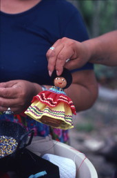 Seminole doll made by Mary Billie being held up for the camera - Big Cypress Reservation, Florida