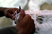 Net maker at work repairing a fishing net - Fernandina Beach, Florida