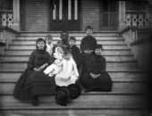 Children and their baby sitter on the steps of the Leon Hotel