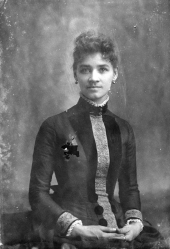 Woman in dress with embroidered front and cuffs.