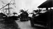 Cars driving by boats washed ashore from the 1926 hurricane - Miami, Florida.