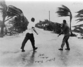 View from the Dupont Plaza of men walking in Hurricane Betsy : Miami, Florida.