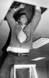 Florida Senator Bob Graham pushing speaker wire into a drop ceiling