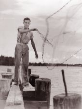 Unidentified young man casting net for mullet - Riviera Beach, Florida.