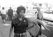 Young white man stripping poster from young black woman's hands - Tallahassee, Florida.