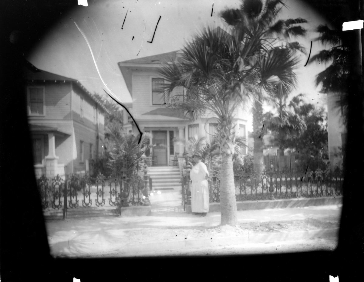 Lincolnville resident Mary “Mae” Martin standing outside the gate to her home (1920s).